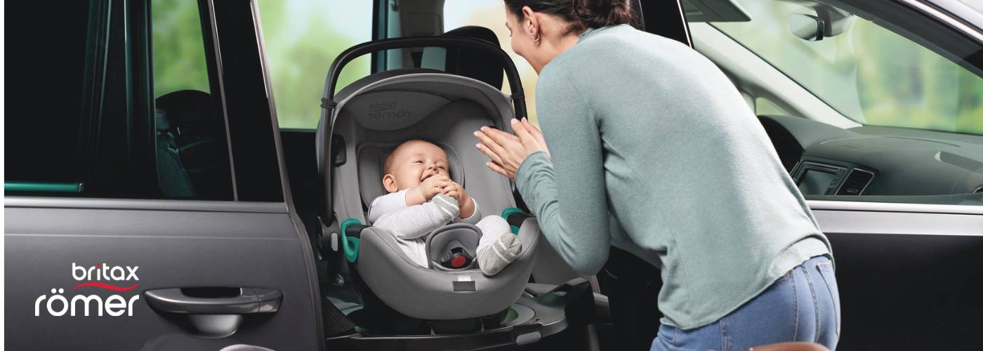 mama colocando a su beb&eacute; en una silla giratoria Britax Romer
